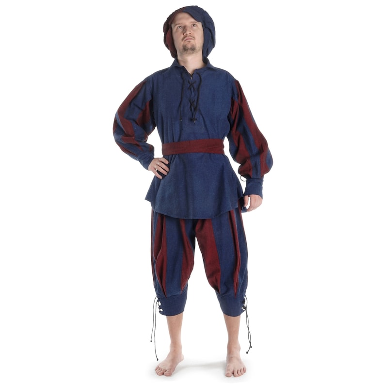 May include: A blue and red striped tunic and pants costume with a matching blue hat. The tunic has a lace-up neckline and a red belt. The pants are gathered at the knees and have a lace-up detail at the ankles.