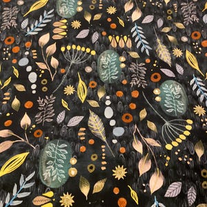 May include: A dark fabric with a repeating pattern of botanical elements. The design features leaves, sprigs, and floral shapes in shades of gold, orange, blue, and green against a black background. The overall effect is a watercolor-like illustration.