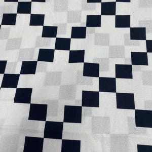 May include: Black and white checkered fabric with a pixelated pattern.