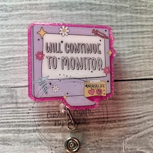 May include: Pink glitter badge reel with a computer screen design. The screen says "Will Continue To Monitor" and has a sticky note that says "#NurseLife".