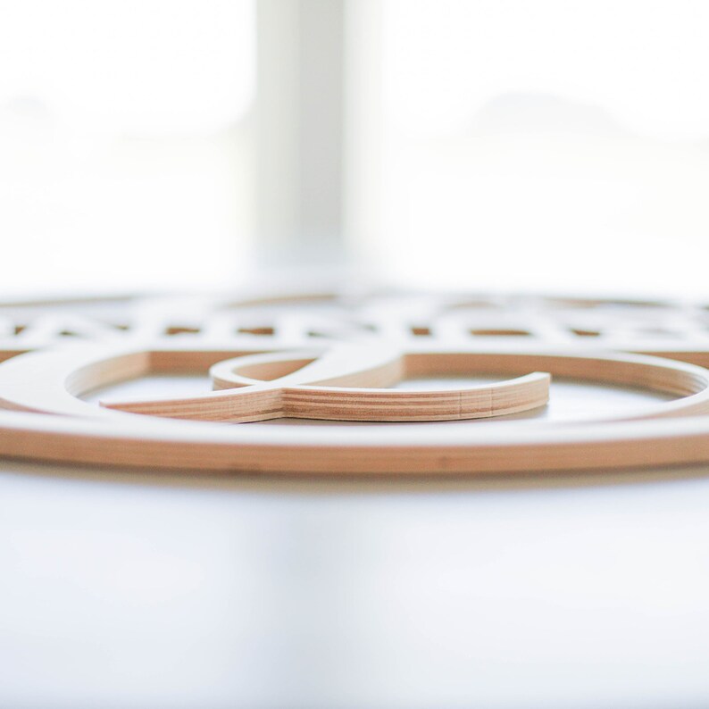 May include: Close-up of a wooden wall decor with a circular design. The design is made of multiple layers of wood, creating a three-dimensional effect.