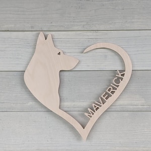 May include: A wooden heart-shaped cutout with a dog silhouette and the name "Maverick" inscribed inside the heart.