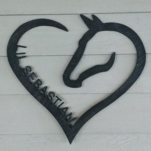 May include: Black wooden heart-shaped sign with a horse head silhouette and the name "Sebastian" cut out.