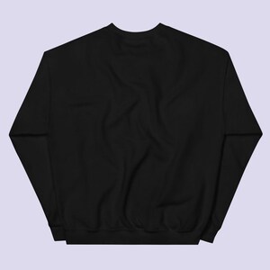 May include: A black sweatshirt with long sleeves and a crew neck.