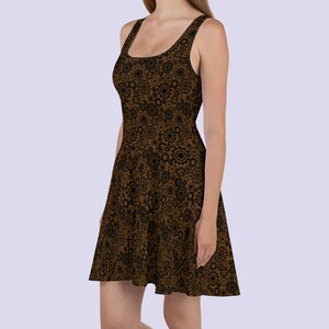 May include: A brown and black sleeveless dress with a pattern of gears and cogs. The dress has a fitted bodice and a flared skirt.