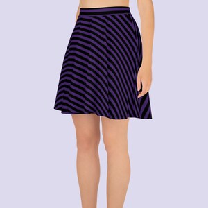 May include: A purple and black striped skater skirt. The skirt is made of a stretchy fabric and has a flared silhouette.
