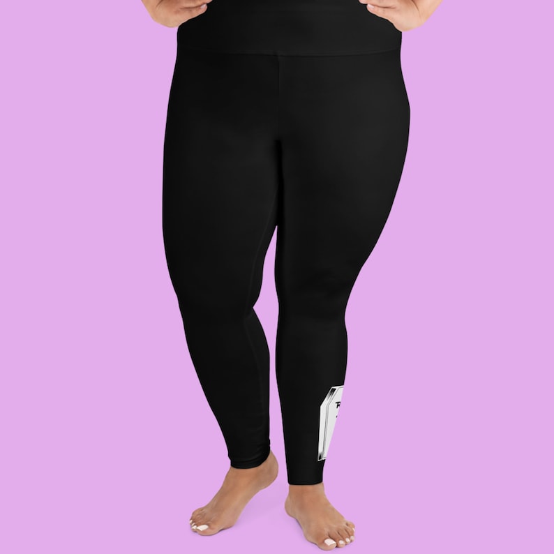May include: Black leggings with a white graphic of a coffin on the right leg.