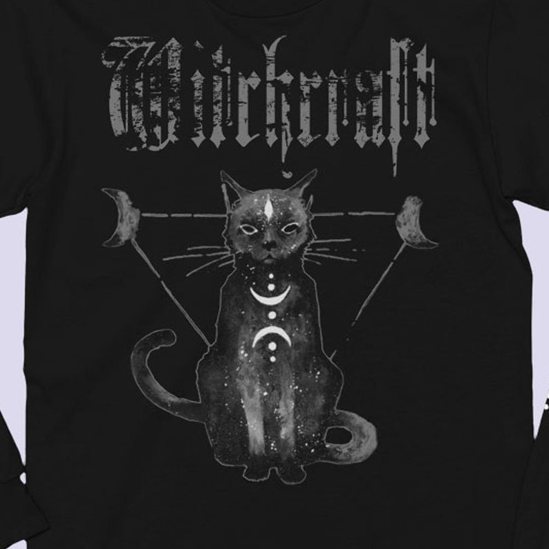 Pode incluir: Camiseta preta de manga comprida com uma ilustra&ccedil;&atilde;o de um gato preto e a palavra "WIRKRAFFT" em letras brancas. O gato est&aacute; rodeado por um tri&acirc;ngulo com luas crescentes em cada ponto.