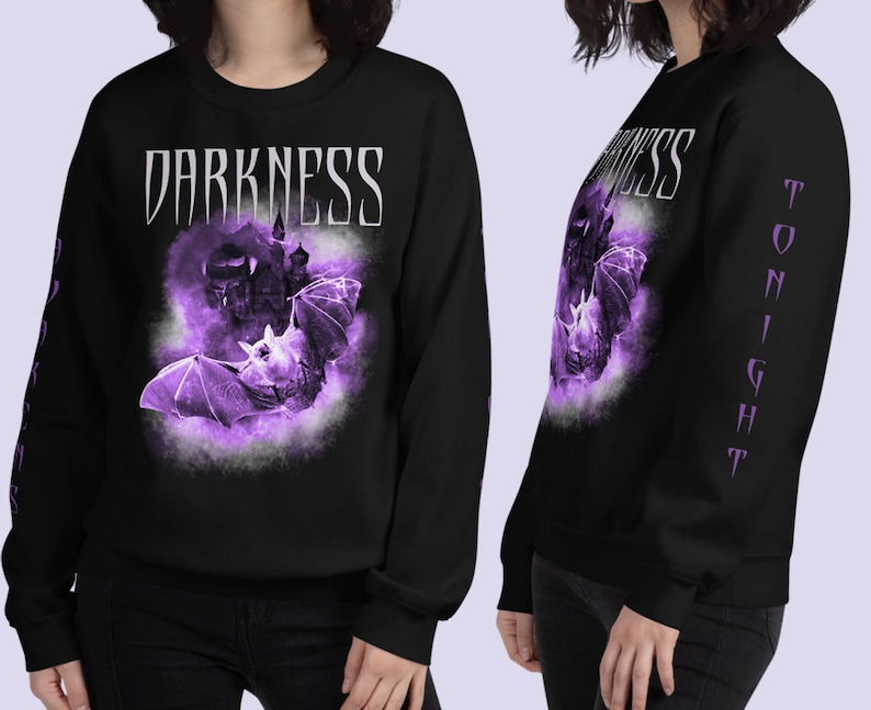 May include: Black long-sleeve sweatshirt with a purple bat and castle graphic and the text "DARKNESS" on the front. The left sleeve has the text "TONIGHT" in purple.