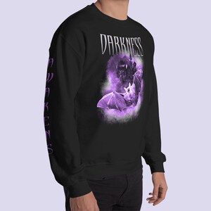 May include: Black sweatshirt with a purple bat graphic and the text "DARKNESS AWAKENS" on the sleeves.