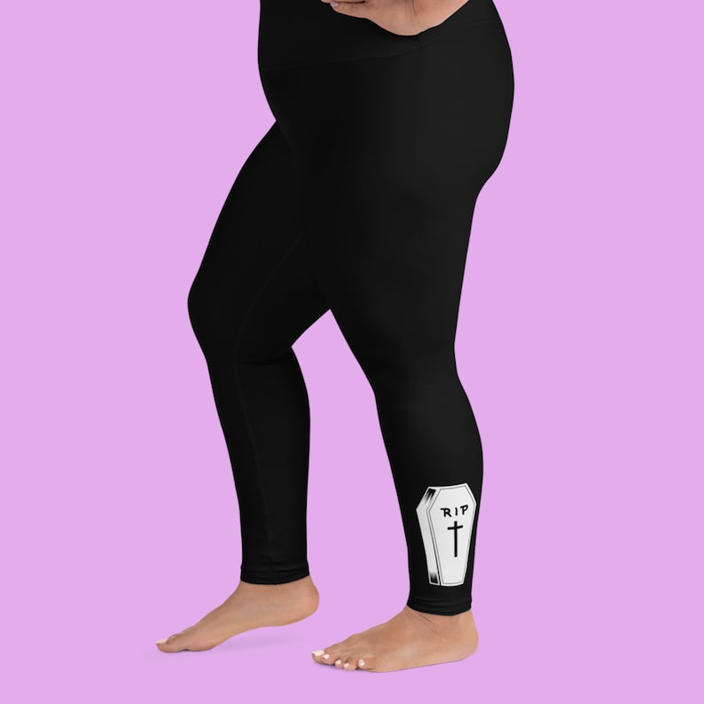 May include: Black leggings with a white coffin graphic that says "RIP" and has a cross on it.