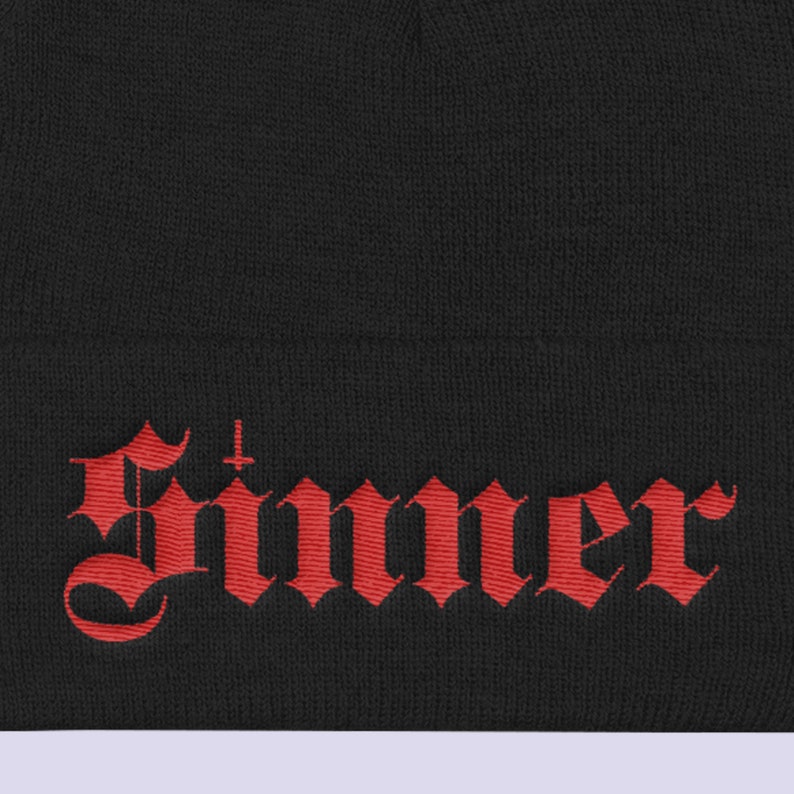 May include: Black beanie with a red embroidered word "Sinner" in a gothic font.