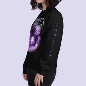 May include: Black long-sleeve sweatshirt with a purple graphic of a bat and the word "Darkness" on the front. The sleeve has the word "Tonight" printed vertically in purple.