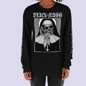 May include: Black long-sleeve t-shirt with a graphic of a nun with two skulls and the text "BLACK+MASS" printed on the front. The sleeves have the text "PRAISE THE LORD" and "ALL HAIL SATAN" printed on them.