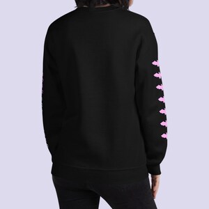 May include: Black sweatshirt with pink bat silhouettes on the sleeves.
