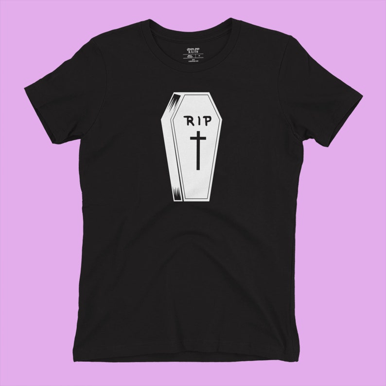 K&ouml;nnte beinhalten: Schwarzes T-Shirt mit einem wei&szlig;en Aufdruck eines Sarges mit dem Text "RIP" und einem Kreuz.