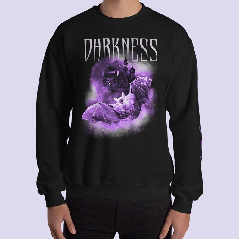 May include: Black long-sleeve sweatshirt with a purple bat and castle graphic and the text "DARKNESS" in white.