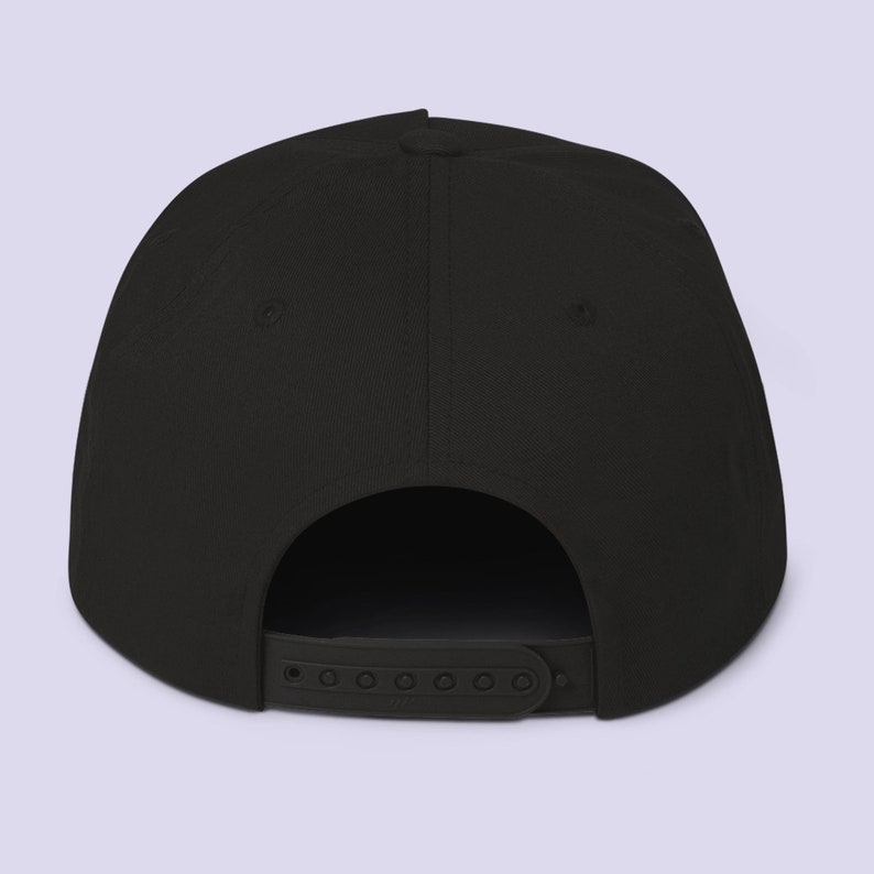 Puede incluir: Gorra de b&eacute;isbol negra, sin estructura, de visera plana, con una correa ajustable negra en la parte posterior.