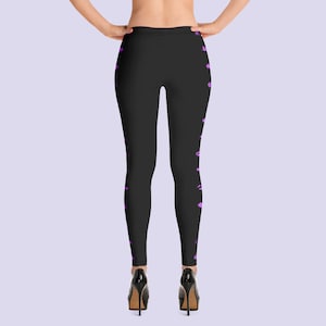 May include: Black leggings with a purple abstract pattern on the sides. The leggings are fitted and have a high waist.