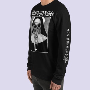 May include: Black long-sleeve t-shirt with a white graphic of a nun with a skull face holding a rosary and a cross. The text "BLACK MASS" is above the graphic. The sleeve has the text "AVE SATANIS" and a pentagram.