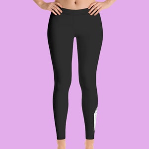 May include: Black leggings with a white graphic design on the right leg.
