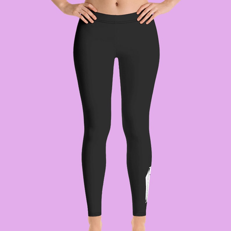 May include: Black leggings with a white graphic design on the right leg.