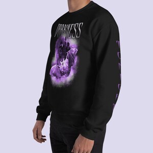 May include: Black sweatshirt with a purple graphic of a bat and a castle with the text "DARKNESS" on the front. The sleeves have the word "DARKNESS" printed vertically in purple.