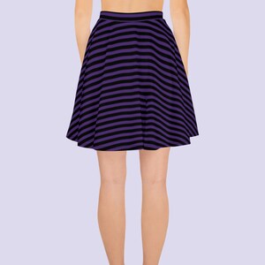 May include: A purple and black striped skirt with a flared silhouette.