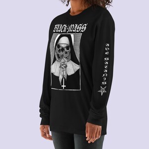 May include: Black long-sleeve shirt with a white graphic of a nun with two skulls and the text "BLACK MASS" on the front. The left sleeve has the text "AVE SATANIS" and a pentagram.