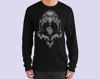 May include: Black long-sleeve shirt featuring a detailed graphic of a skull with horns, a skull, and inverted crosses. The design is in shades of gray and white. The shirt is made of a soft material.