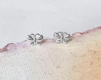 Op de afbeelding: Een paar zilveren vlinder oorringen. De oorringen zijn klein en delicaat, en ze hebben een eenvoudig, elegant ontwerp.