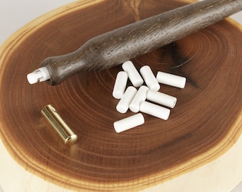 May include: A wooden pencil sharpener with a dark brown wooden handle and a brass cap. The sharpener comes with a pile of white eraser refills.