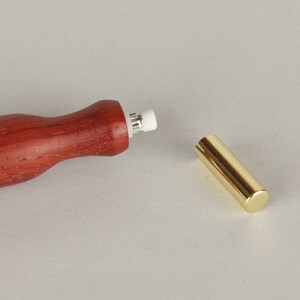 Peut inclure: Un crayon en bois avec un porte-gomme en m&eacute;tal dor&eacute;. Le crayon est rouge et pr&eacute;sente un grain de bois naturel. La gomme est blanche et est fix&eacute;e &agrave; l'extr&eacute;mit&eacute; du crayon.