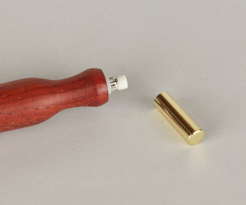 Peut inclure: Un crayon en bois avec un porte-gomme en m&eacute;tal dor&eacute;. Le crayon est rouge et pr&eacute;sente un grain de bois naturel. La gomme est blanche et est fix&eacute;e &agrave; l'extr&eacute;mit&eacute; du crayon.