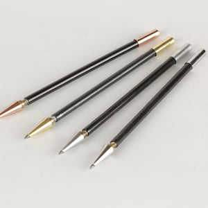 Puede incluir: Cuatro bolígrafos negros con puntas metálicas de diferentes colores. Las puntas son de cobre, oro, plata y plata oscura.