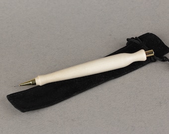 May include: A wooden pencil with a gold tip, resting in a black velvet pouch.
