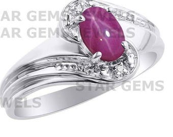 May include: A silver ring with a pink oval star ruby gemstone and small diamonds set in the band.