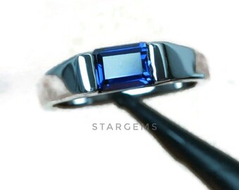 May include: A silver ring with a blue rectangular gemstone set in the center.