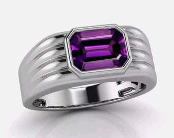 May include: A silver ring with a rectangular, faceted amethyst gemstone set in a bezel setting. The band has a textured design.