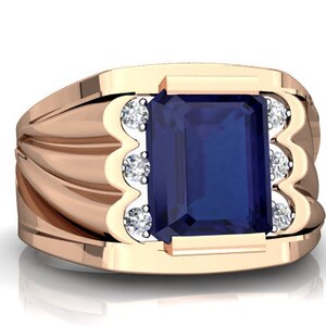 Könnte beinhalten: Ein goldener Ring mit einem großen, dunkelblauen, smaragdgeschliffenen Edelstein, der von kleineren, klaren Edelsteinen umgeben ist.