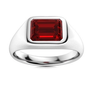Peut inclure: Une bague signet en argent avec une pierre précieuse rouge carrée sertie dans un sertissage à bélière.