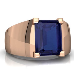 Könnte beinhalten: Ein Ring aus Roségold mit einem großen, dunkelblauen, smaragdgeschliffenen Edelstein.