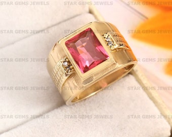 May include: A gold ring with a large, rectangular, pink gemstone and two smaller, round, white gemstones. The ring is set in a gold band with a textured design.