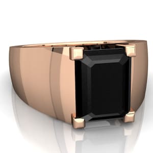 May include: A rose gold ring with a black square-shaped gemstone.