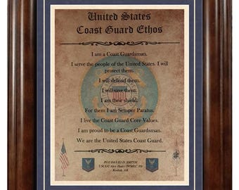 May include: Framed print of the United States Coast Guard Ethos. The text is displayed on a parchment-style background, surrounded by a blue mat and a dark brown wooden frame. The print includes the Coast Guard emblem and the American flag.