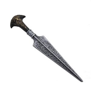May include: A decorative dagger with a silver blade and a detailed handle. The handle features a dark brown grip and a gold-colored top with an ornate design. The blade has a textured appearance.