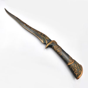 May include: A black and gold dagger with intricate swirling patterns on the blade and handle.