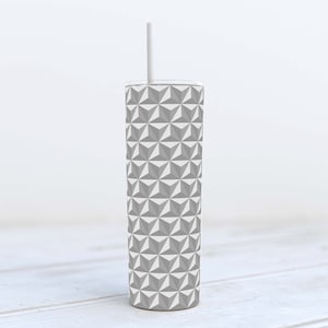 May include: A gray and white geometric patterned tumbler with a white straw. The tumbler is made of stainless steel and has a double-walled design to keep drinks cold or hot.