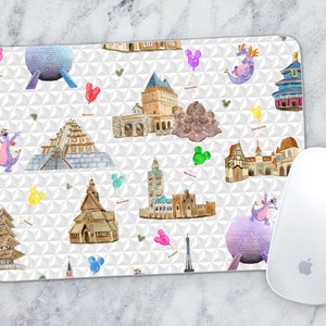 May include: A white mouse mat featuring a colourful pattern of Disney World landmarks and characters. The landmarks include Spaceship Earth, Cinderella Castle, and the Eiffel Tower. The characters include Mickey Mouse, Minnie Mouse, and a purple dragon.