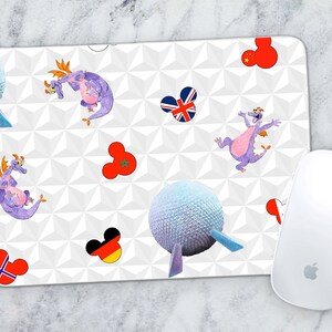 May include: White mouse mat with a white, grey, and black geometric pattern. The mouse mat features purple cartoon dragons, a white sphere, and various flags including the United States, United Kingdom, Morocco, Germany, and Norway.